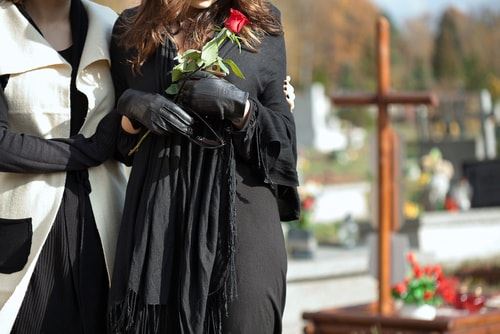 A widow being comforted at a grave site