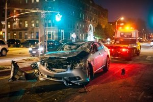 totaled car on the street at night